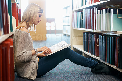 Buy stock photo Woman, library and reading book on floor for studying education or university scholarship, learning or college. Female person, campus and academic exam in Canada for research, lesson or literature