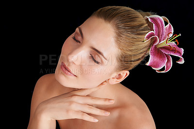 Buy stock photo A beautiful young woman with a flower in her hair isolated on black