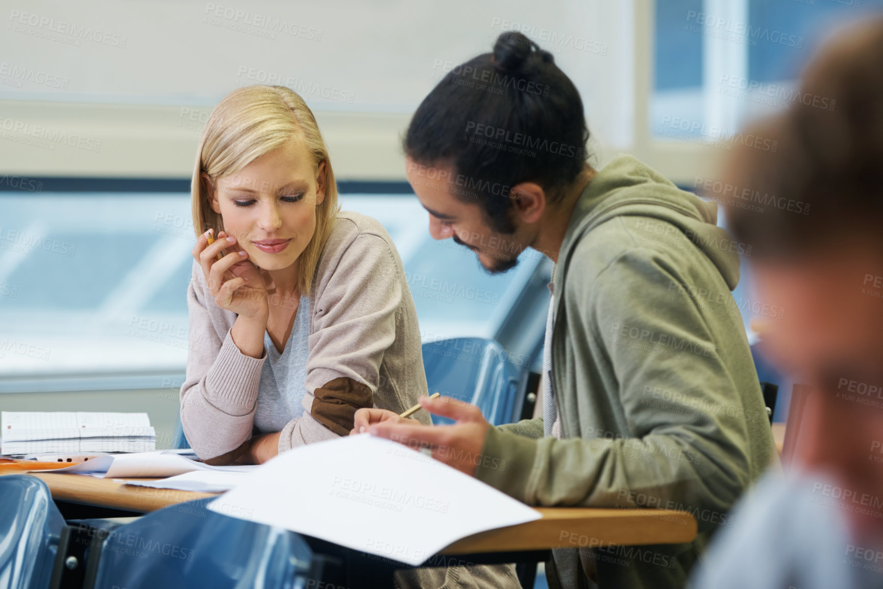 Buy stock photo Discussion, university and students in classroom for studying with text book for test or exam. Conversation, writing and young people working on college assignment together in lecture hall at academy