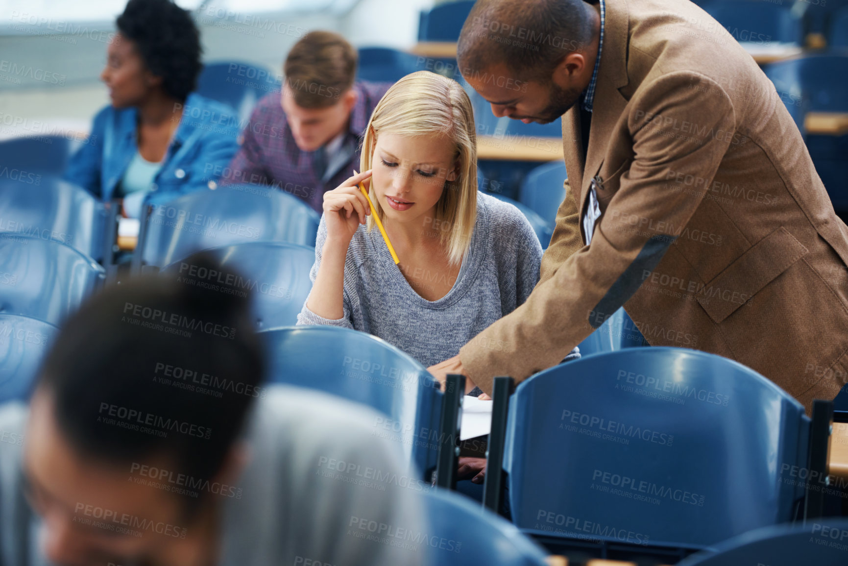 Buy stock photo University, helping and professor with student in classroom studying for test, exam or assignment. Education, learning and teacher talking and explaining college information to woman in lecture hall.