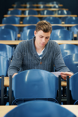 Buy stock photo Lecture hall, college and man with thinking, student and knowledge with exam and education. Person, writing and guy in classroom with test and learning with studying and creativity with research