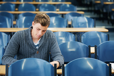 Buy stock photo Lecture hall, thinking and man with university, student and college with exam and education. Person, writing and guy in classroom with test and learning with studying and creativity with knowledge