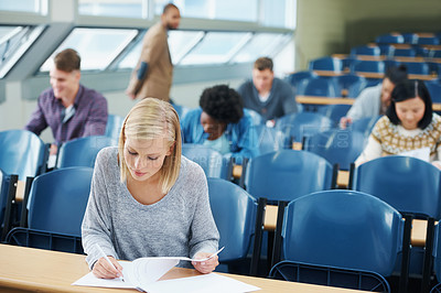 Buy stock photo Writing, university and woman student in classroom studying for test, exam or assignment. Education, scholarship and female person working on project with knowledge in lecture hall for learning.