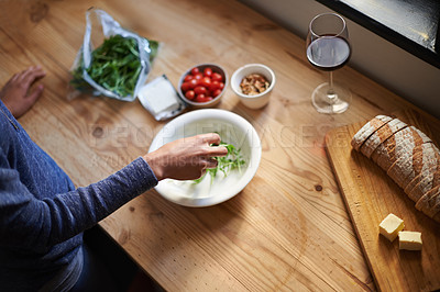 Buy stock photo A young woman making a salad in her kitchen