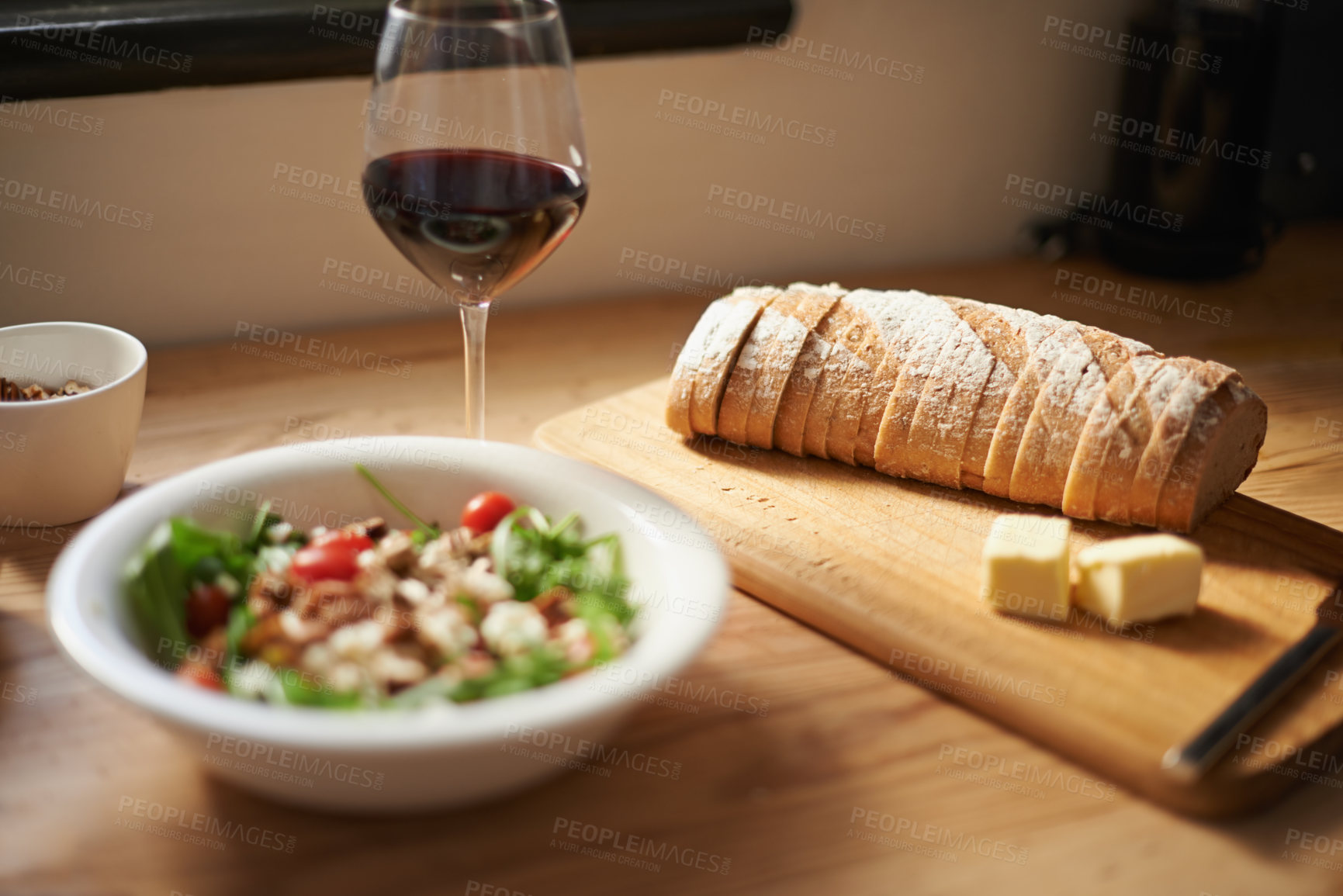Buy stock photo Food, drink and dinner on table for nutrition, red wine and bread with salad for health and wellness at home. Supper meal, vegetables and herbs for eating with alcohol beverage on kitchen counter 