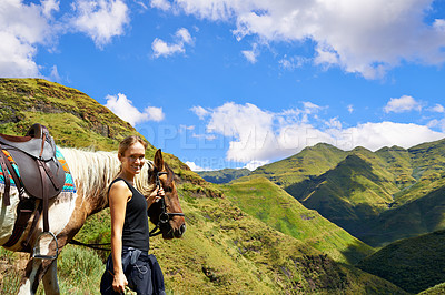 Buy stock photo A young woman with her horse on a mountain trek