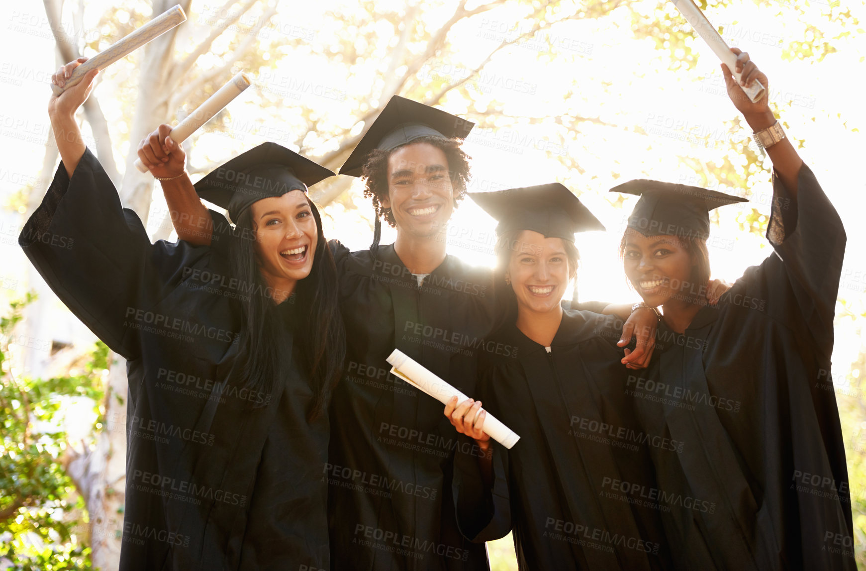 Buy stock photo A group of smiling college graduates celebrating their graduation