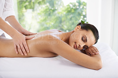 Buy stock photo Shot of a young woman enjoying a massage at a spa