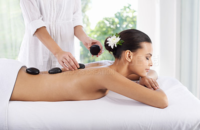 Buy stock photo Hot stone, woman and hands massage spine for skincare, beauty and pamper body for wellness at luxury salon. Therapist, rocks and back of person at spa for treatment, relax or health with masseuse