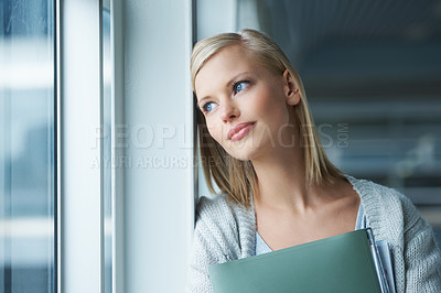 Buy stock photo A thoughtful young college student gazing out a window