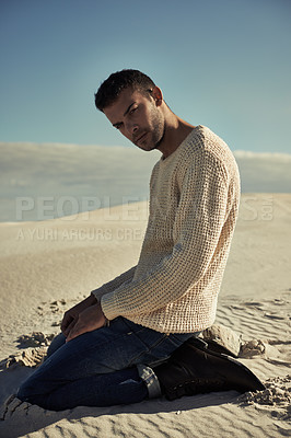 Buy stock photo Man, fashion and portrait in desert, style and sun for Dubai travel and vacation while kneeling. Male person, modern and sand dunes on holiday, trip and cool confidence outdoor in nature in Abu Dhabi