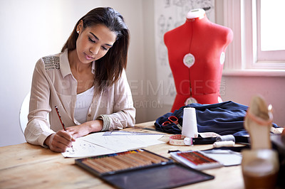 Buy stock photo A fashion designer creating sketches in her office