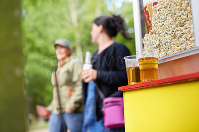 Buy stock photo Beer, popcorn and vendor at festival closeup outdoor with people on blurred background for event or party. Summer, food or snack with alcohol in plastic cup on counter for drinking and celebration