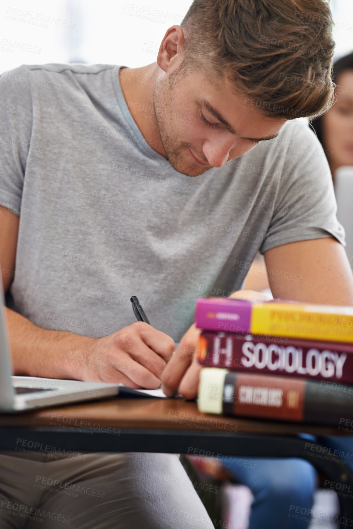 Buy stock photo Student at a desk, man and writing with textbooks, education and knowledge with exams and test. Person, college and guy with ideas and laptop with inspiration and studying with learning or university