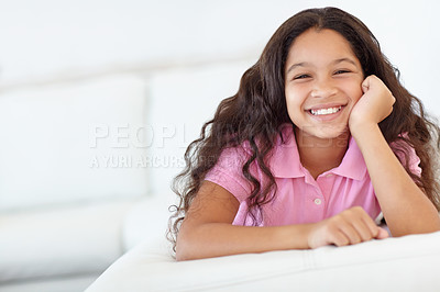 Buy stock photo Smile, sweet and portrait of girl child at her home with positive, good and confident attitude. Happy, cute and face of young kid from Colombia sitting and relaxing in living room at modern house.