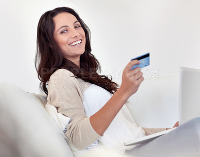 Buy stock photo Portrait of an attractive woman holding a credit card while using a laptop