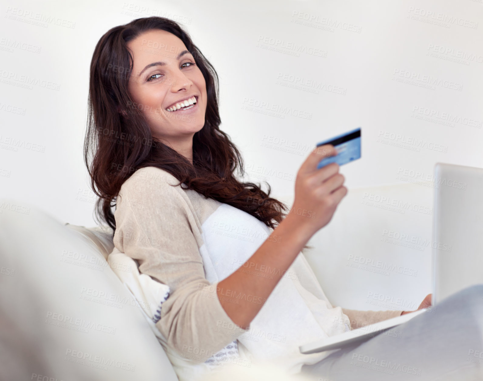 Buy stock photo Portrait of an attractive woman holding a credit card while using a laptop