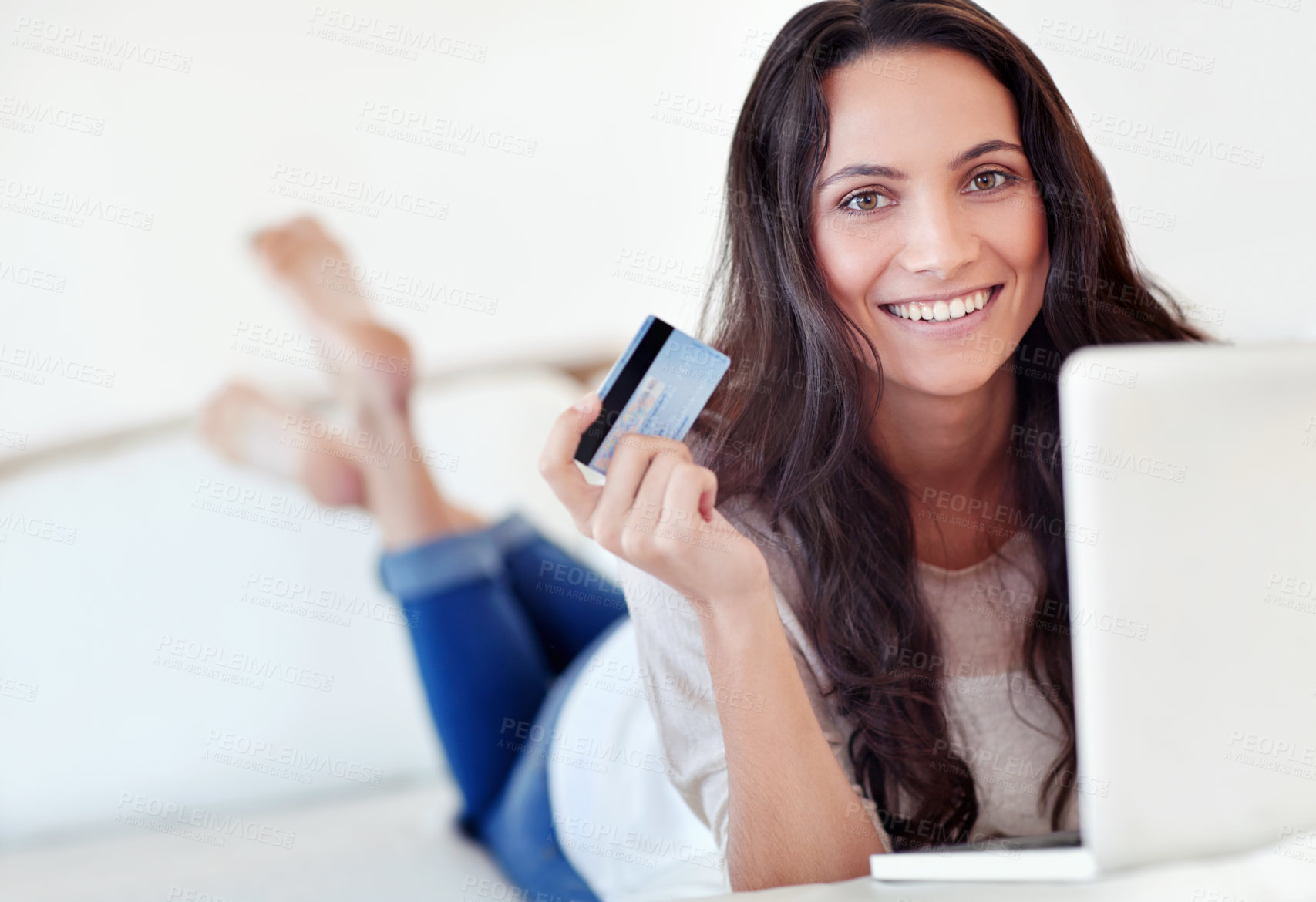 Buy stock photo Portrait of a young woman holding a credit card while using a laptop