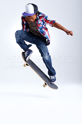 Buy stock photo Skateboard trick, jump or African kid in studio with trendy fashion, skill or mockup space with cool style. Skater, performance or young child skateboarding with energy isolated on white background