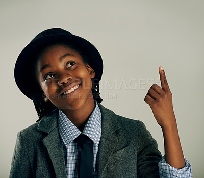Buy stock photo Studio shot of a stylish ethnic boy smiling and pointing up at copyspace