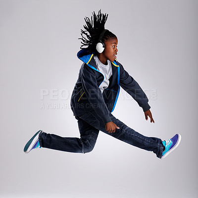 Buy stock photo Black child, jump and headphones for fashion in studio for hiphop in backdrop of white background. Boy, funky and  happiness of skilled performer with smile of youth for kids clothes and dance