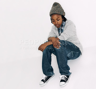Buy stock photo Child, sad and fashion with problem and frustrated with depression in a studio. Youth, annoyed and bored African male boy with casual fashion and gen z clothes sitting with white background and issue