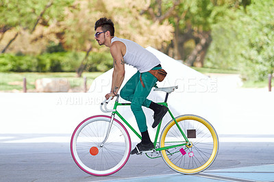 Buy stock photo A handsome young man riding his bicycle outdoors