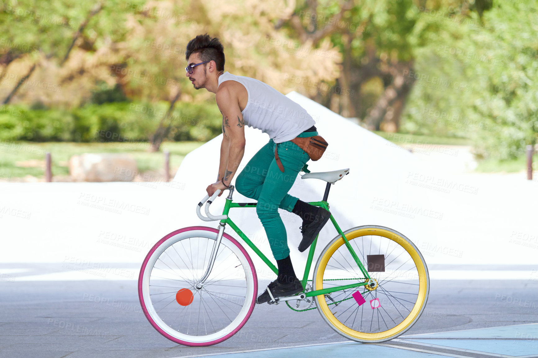 Buy stock photo A handsome young man riding his bicycle outdoors