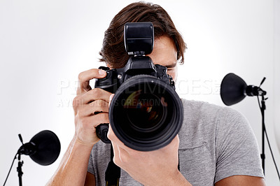 Buy stock photo Man, camera lens and photography with technology in studio, press or media for news on white background. Photographer, photo journalist and creative with paparazzi, equipment or gadget with closeup