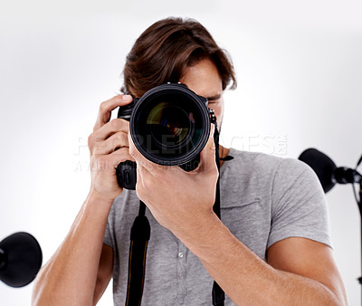 Buy stock photo Man, camera lens and photography with tech in studio, press or media for news on white background. Photographer, photo journalist and creative with paparazzi, equipment and closeup in studio