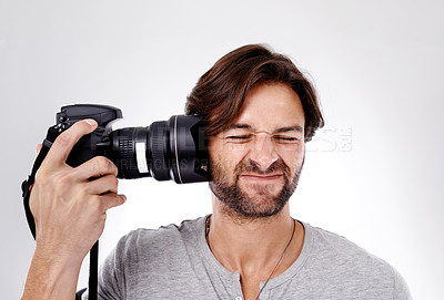 Buy stock photo Photographer, digital and man pressing his camera against his ear on a white studio background. Artistic, person or model with equipment and technology with creativity or media with deadline and tool