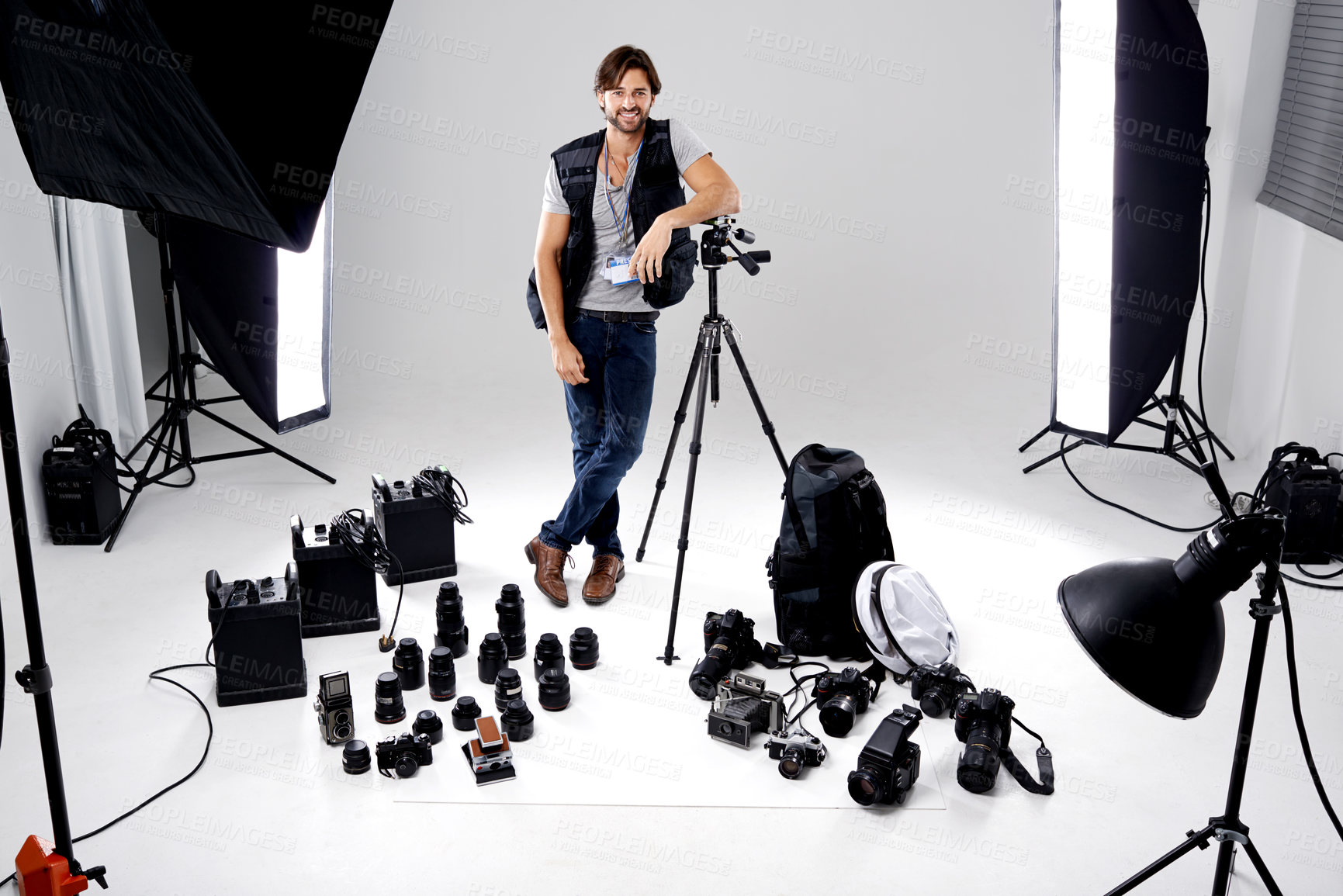 Buy stock photo Portrait, smile and man with gear, photography and equipment in a work studio with confidence. Person, photographer and entrepreneur with tools or lights with startup and freelancer with professional