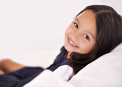 Buy stock photo Smile, relax and portrait of child on sofa for playful, fun and resting on weekend in living room. Happy, childhood and face of young girl alone on couch for comfortable, playing and lying in home
