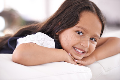 Buy stock photo Happy, relax and portrait of child on sofa for playful, fun and resting on weekend in living room. Smile, childhood and face of young girl alone on couch for vacation, holiday and free time in home