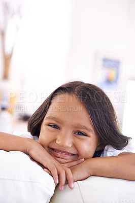 Buy stock photo Playful, relax and portrait of child on sofa for lying, fun and resting on weekend in living room. Smile, home and face of young girl alone on couch for happiness, comfort and childhood in Brazil