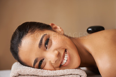 Buy stock photo Portrait of happy woman, rock or back massage in spa to relax for zen, resting or wellness physical therapy. Face of girl smiling in salon to exfoliate for body healing treatment or hot stone therapy