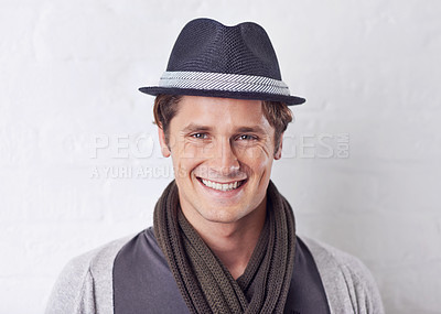 Buy stock photo Happy, fashion and portrait of man by wall with casual, cool and trendy outfit for confidence. Smile, handsome and young male person with attractive style and hat standing by white brick background.
