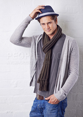 Buy stock photo Hat, fashion and portrait of man by wall with casual, cool and trendy outfit for confidence. Smile, handsome and happy young male person with attractive style standing by white brick background.