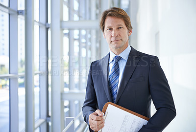 Buy stock photo Shot of a mature businessman holding a clipboard in an office building