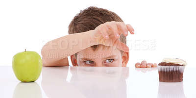 Buy stock photo Cupcake, apple and child with food choice between unhealthy junk food and healthy nutrition product. Table, studio and kid boy decision between fruit and chocolate candy isolated on white background