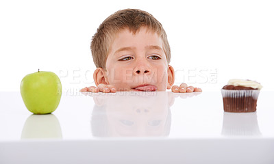 Buy stock photo Cupcake, apple and kid with food choice between unhealthy junk food and healthy nutrition product. Table, studio and kid boy decision thinking of fruit or chocolate candy isolated on white background