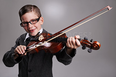 Buy stock photo Smile, music and child with violin in studio for practice with suit and glasses for fashion. Happy, style and portrait of young boy kid play string instrument with spectacles by gray background.