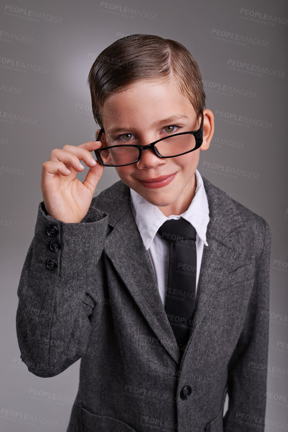 Buy stock photo Portrait, costume and boy with glasses, suit and Halloween dress up on a grey studio background, Face, person and model with fun and eyewear with child development and business with retro clothes