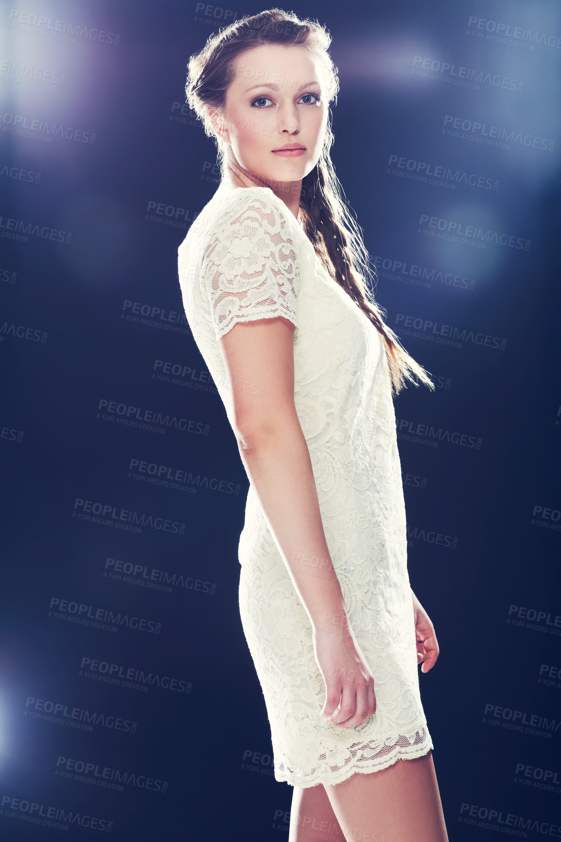 Buy stock photo Cropped view of a beautiful young woman in a lacy cocktail dress against a blue background