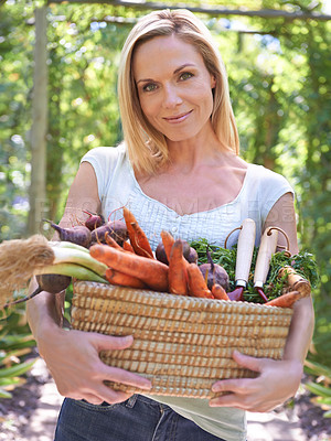 Buy stock photo A woman holding a basket of fresh vegetables