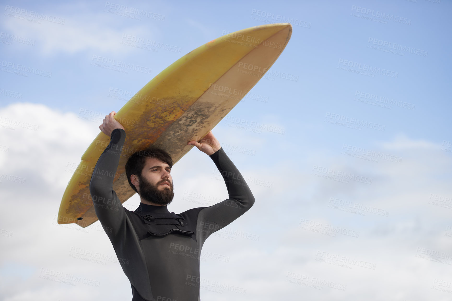 Buy stock photo Man, surfboard and adventure at beach on holiday, weekend and sports for fitness in water. Male person, balance and cloudy sky on tropical island, wetsuit and travel on vacation or getaway for peace