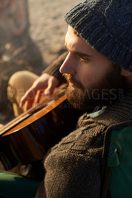 Buy stock photo Face, beach and man playing guitar from above to relax on holiday or vacation for travel in summer. Nature, music or thinking and young hipster person with instrument on sand by ocean or sea