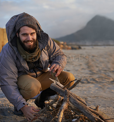 Buy stock photo Portrait, smile and man at beach with campfire on holiday, vacation or travel toe prepare for winter outdoor alone. Happy person, wood and adventure at seashore, leisure and recreation in Canada