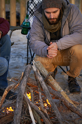 Buy stock photo Campfire, wood and men by beach for travel on vacation, adventure or holiday camping. Nature, outdoor and young male people sitting on chair in sand with flame for heat on weekend trip in winter.