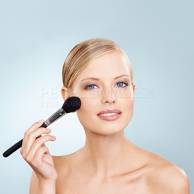 Buy stock photo Cosmetics, brush and portrait of woman in studio with confidence, natural makeup or facial glow. Glamour, cosmetics and happy face of girl on blue background with healthy skin, shine and wellness.